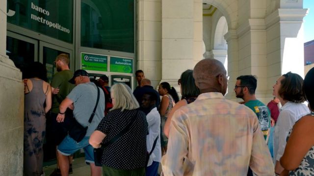 Cubans and foreigners in a bank in Cuba