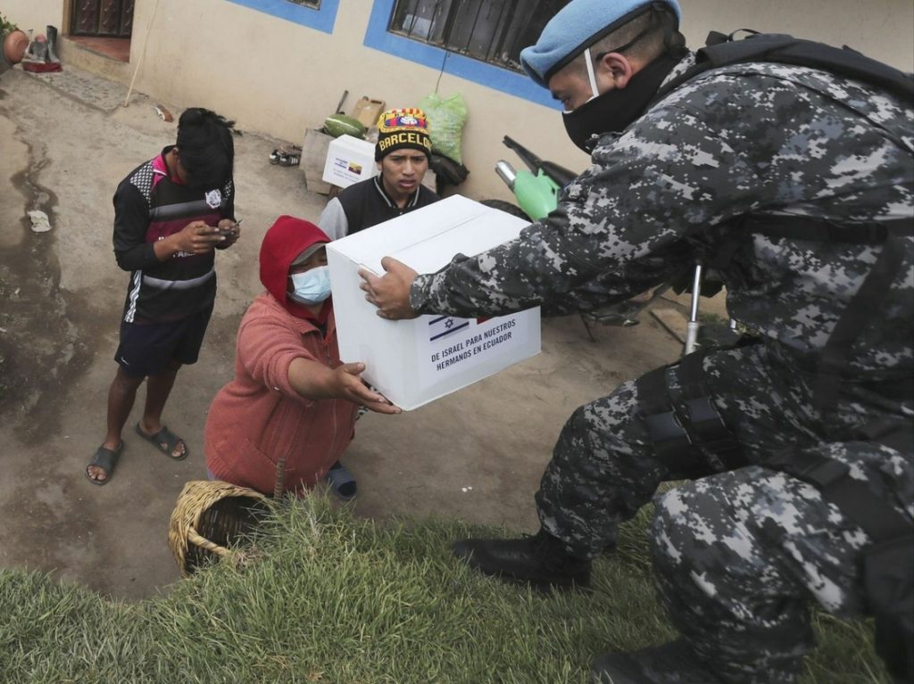 Una familia ecuatoriana recibe una despensa donada por el gobierno de Israel, a las afueras de Quito.