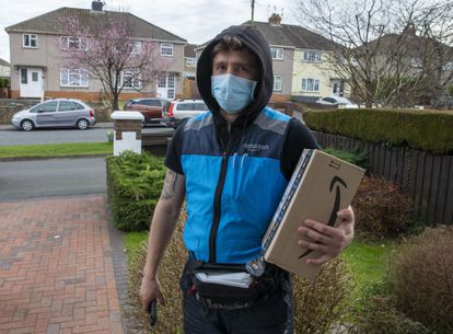 Amazon delivery man delivers a package in Blackwood, Wales, UK.